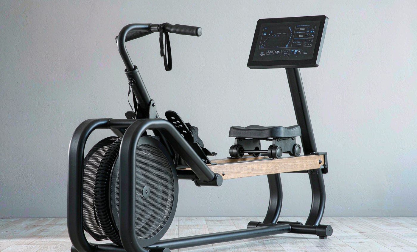 Black rowing machine with wooden rails and an LCD console