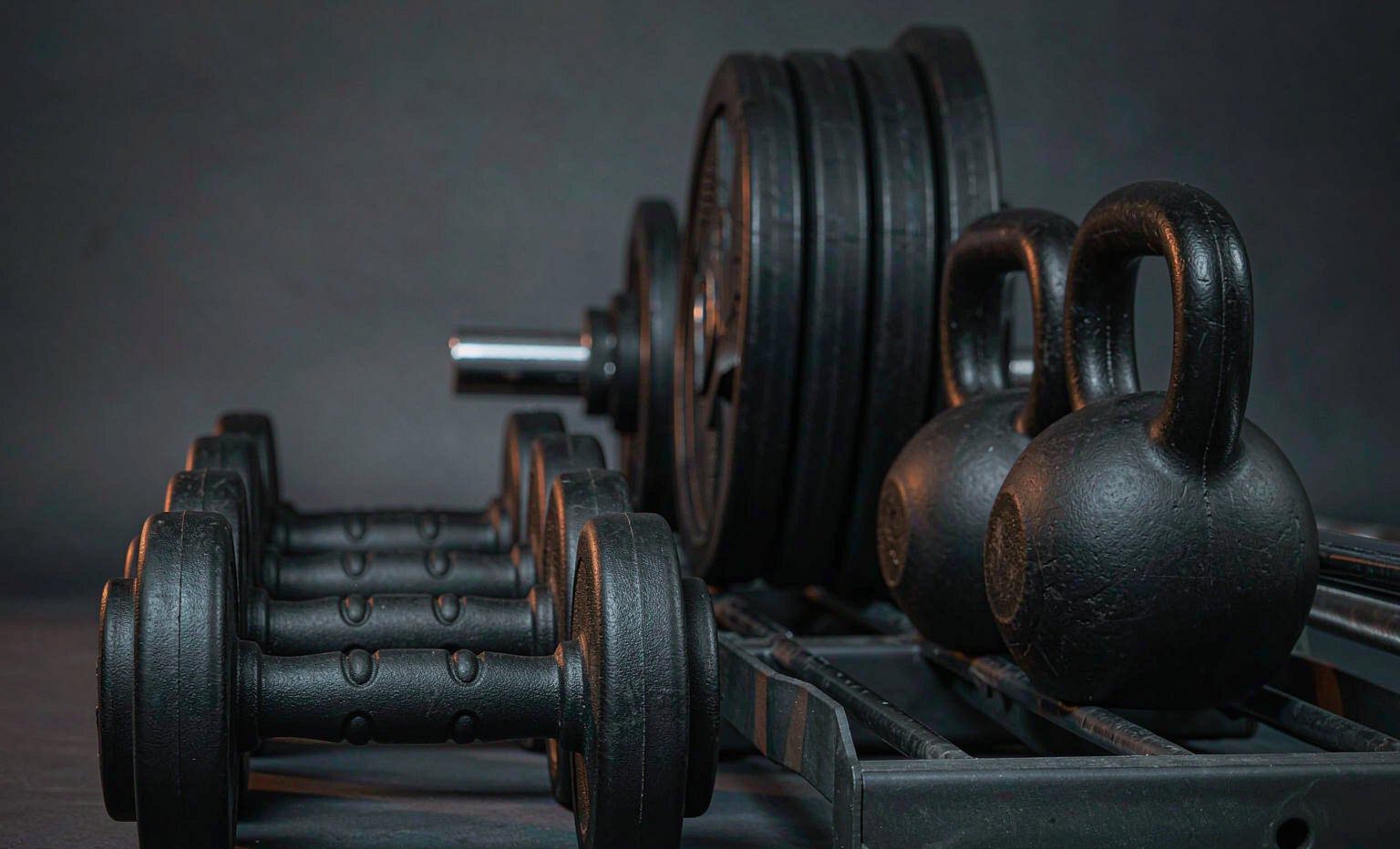 Dumbbells, kettlebells and weight plates on a rack