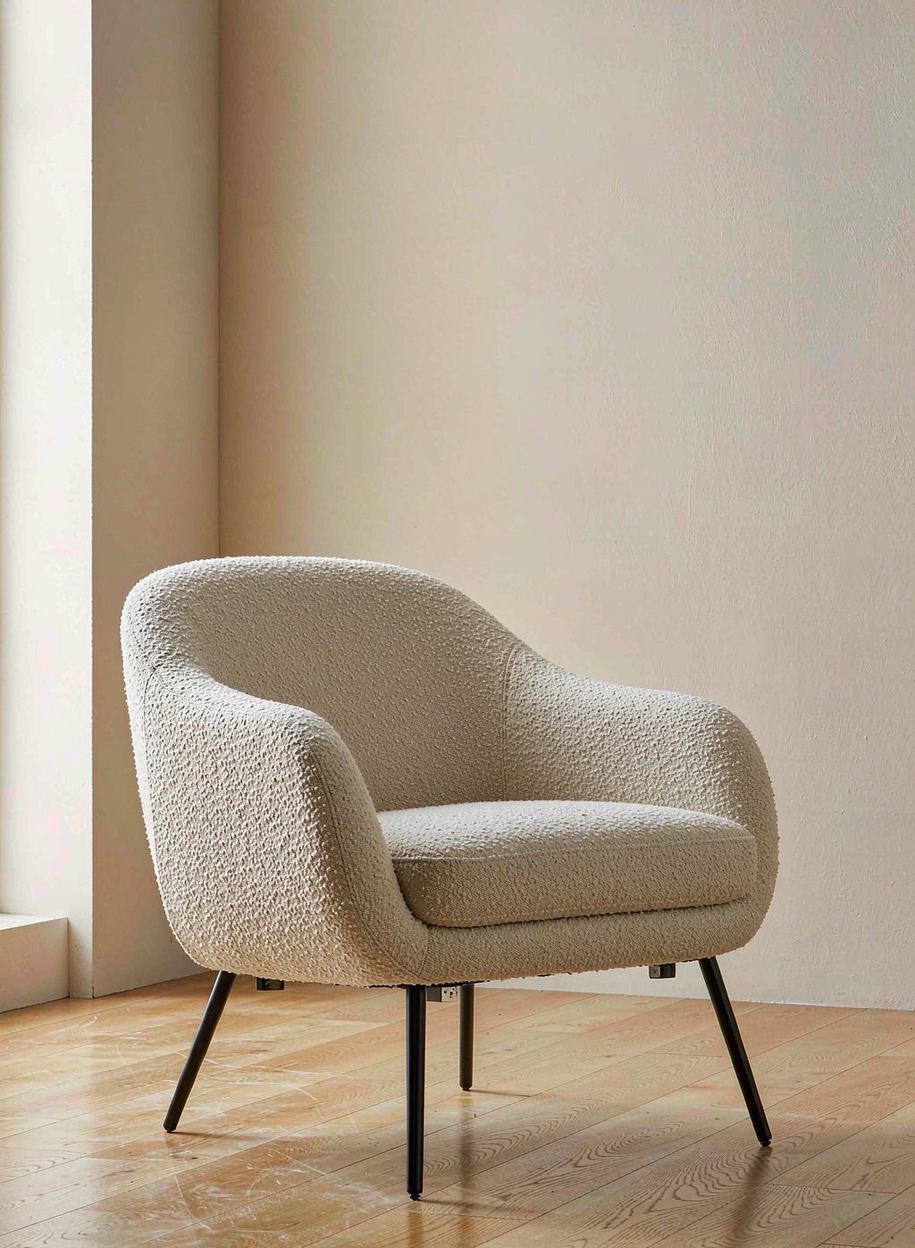 Cream boucle accent armchair on a light oak floor