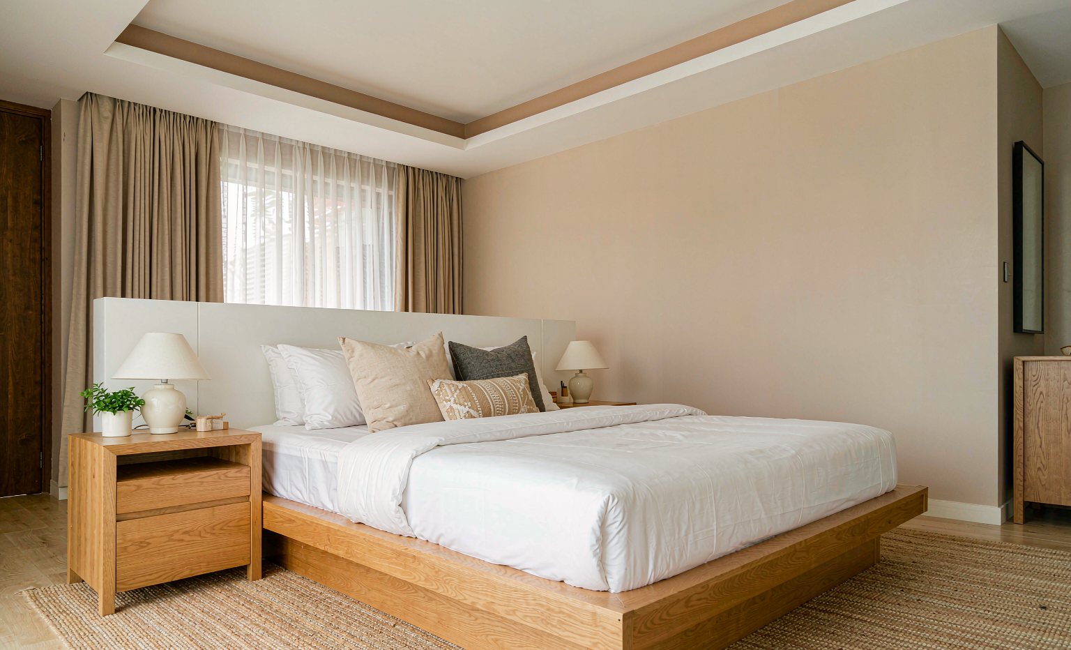 Low oak platform bed with layered linen bedding